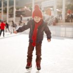 child smiling and ice skating outdoors